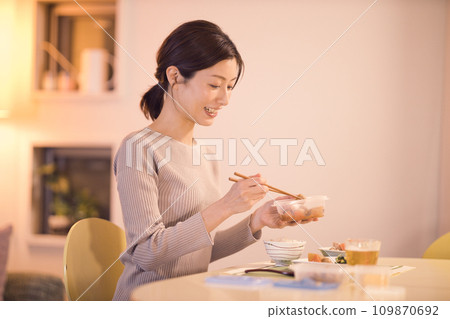 一位女商人的夜間例行公事，用準備好的菜餚吃晚餐 109870692