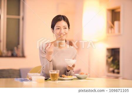 Night routine of a business woman who eats dinner with prepared dishes Night routine of a business woman who eats dinner with prepared dishes 109871105