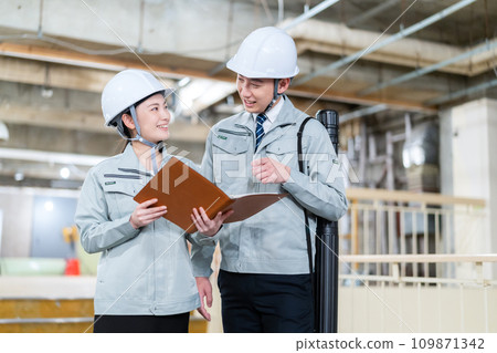Male and female engineers having a meeting at a construction site 109871342