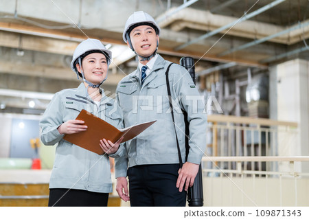 Male and female engineers having a meeting at a construction site 109871343