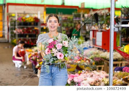 Happy young woman choosing colorful bouquet in flower shop 109872499