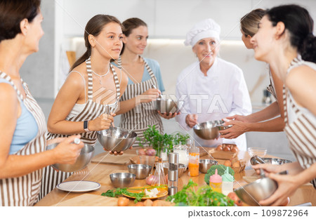 Young female visitor has nice conversation with person facing buddy vis-a-vis at culinary courses Young female visitor has nice conversation with person facing buddy vis-a-vis at culinary courses 109872964