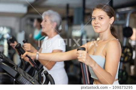 Young woman working out on elliptical machine Young woman working out on elliptical machine 109873295