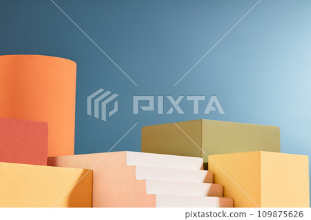Geometric shape podiums decorated against blue background with vacant space. Studio podium or platform product template mockup Geometric shape podiums decorated against blue background with vacant space. Studio podium or platform product template mockup 109875626