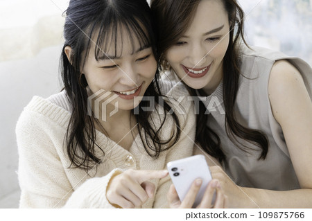 使用智慧型手機的親密姊妹 109875766