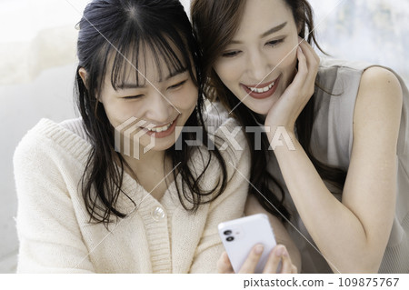 使用智慧型手機的親密姊妹 109875767