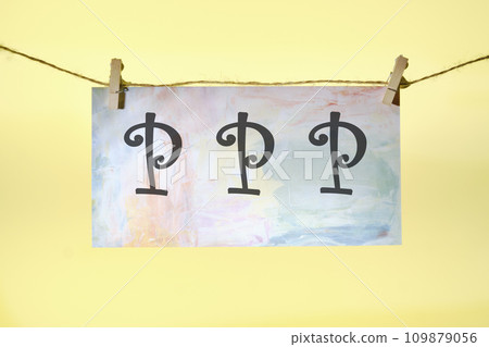 Paycheck Protection Program PPP lettering on colored paper hanging in front of a yellow background with a rope and clothespins Paycheck Protection Program PPP lettering on colored paper hanging in front of a yellow background with a rope and clothespins 109879056