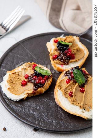canapes with pate, mint leaves and berries, side view 109879657