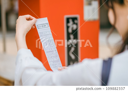 Asian woman drawing fortunes at a shrine (Sueyoshi) 109882337