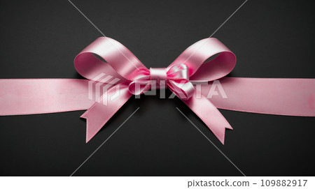 Pink gift ribbon with bow isolated on gray background. Decorative pink bow with horizontal ribbon. bow for page decor isolated on grey. 109882917