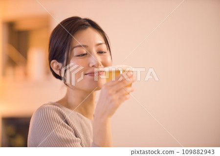Night routine of a business woman having dinner while drinking beer 109882943
