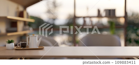 A coffee set and an empty space for display your product on a wooden tabletop in a cosy living room. 109883411