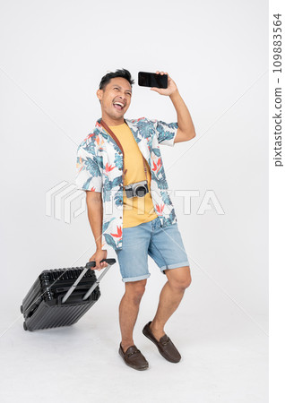 A man in summer clothes is feeling excited to travel and enjoy his summer vacation at the beach. 109883564