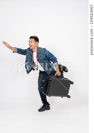 A happy, fun Asian man is jumping with his travel luggage on an isolated white background. 109883667