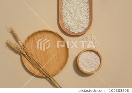 Wooden plates with different shapes and whole rice are displayed on the background. With vitamins B6, B12,etc and minerals, brown rice can help make skin smooth and firm. 109883808