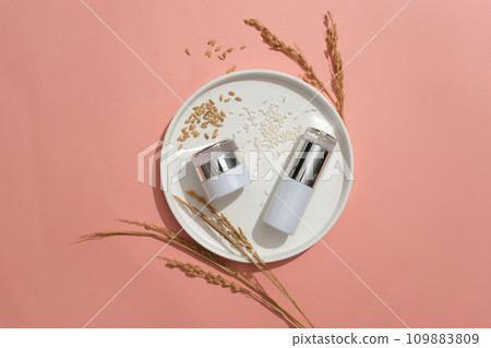 Two cosmetic jars with luxurious design and rice are placed on a round ceramic plate. Copy space for branding and advertising. High-end natural cosmetics concept. 109883809