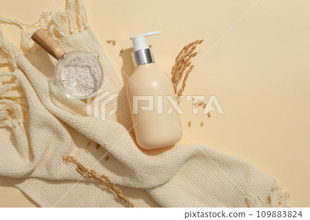 Rice powder is stored in a glass bowl, a cosmetic jar on a beige background. Mockup for cosmetic advertising. The concept of vegan cosmetic-eco friendly. 109883824