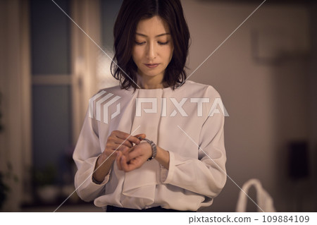 Night routine of a business woman who takes off her jacket and watch Night routine of a business woman who takes off her jacket and watch 109884109