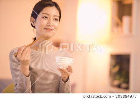 Night routine of a business woman who eats dinner with prepared dishes 109884975