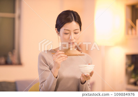 Night routine of a business woman who eats dinner with prepared dishes 109884976
