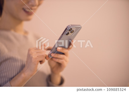 女人在客廳看智慧型手機 夜間例行公事 109885324