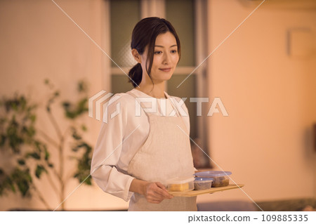 女商人綁著頭髮,準備晚餐 女商人綁著頭髮,準備晚餐 109885335