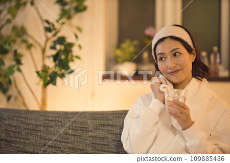 Night routine of a woman drinking water after taking a bath Night routine of a woman drinking water after taking a bath 109885486