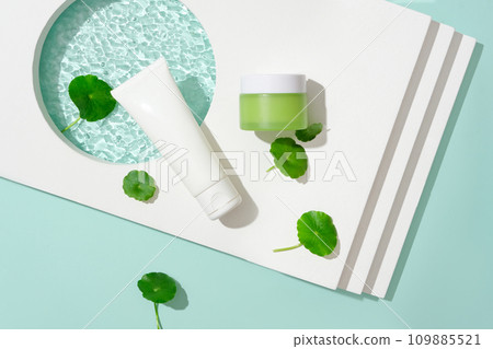 A white tube, a green lotion jar, a podium, and pennywort. Notably, Gotu kola possesses the remarkable capability to stimulate collagen production, contributing to skincare and wellness. 109885521