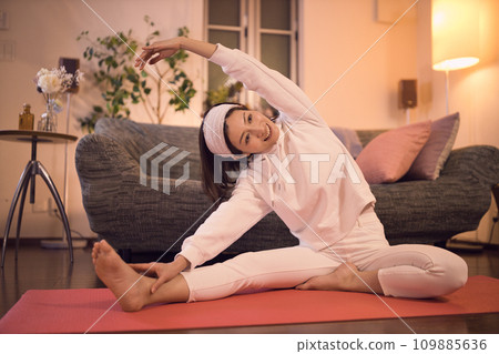 Woman relaxing and stretching night routine Woman relaxing and stretching night routine 109885636