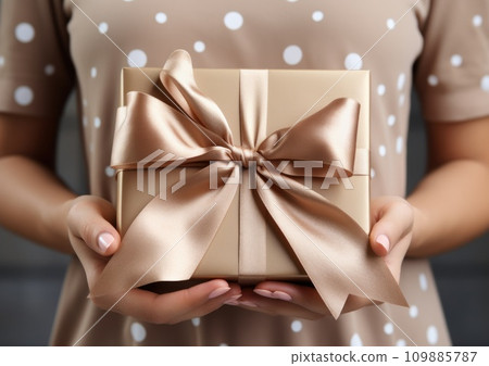 person's hands holding an invitation card with pink ribbon person's hands holding an invitation card with pink ribbon 109885787