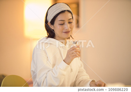 Night routine of a woman drinking water after taking a bath 109886220