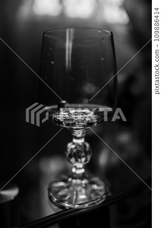 Gold wedding rings on a brown background. Gold wedding rings in a glass of champagne Gold wedding rings on a brown background. Gold wedding rings in a glass of champagne 109886414