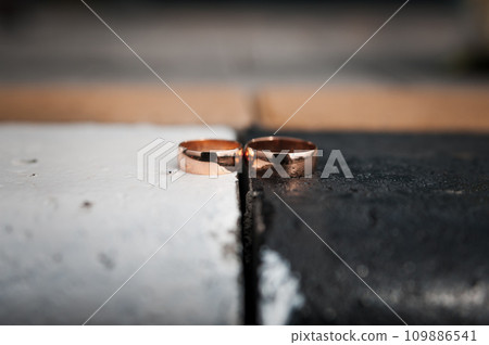 Two gold wedding rings on a black and white background Two gold wedding rings on a black and white background 109886541