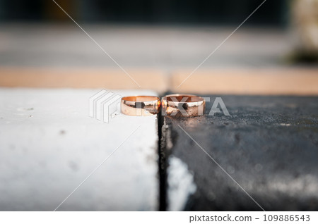 Two gold wedding rings on a black and white background 109886543