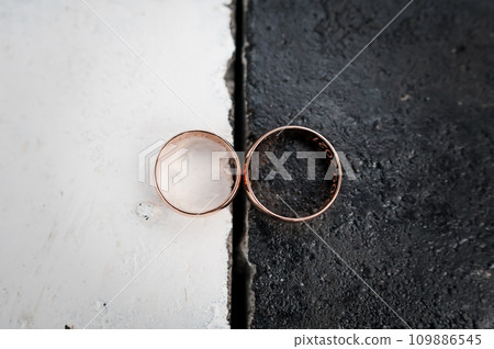 Two gold wedding rings on a black and white background 109886545
