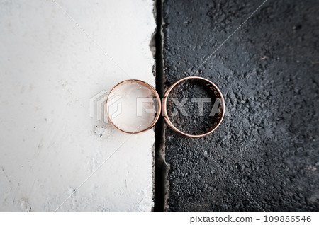Two gold wedding rings on a black and white background 109886546