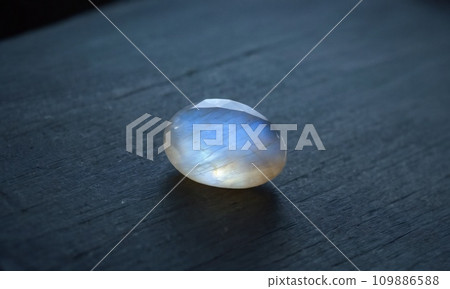 Natural precious moonstone on a gray background. Natural stone adularia 109886588