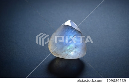 Natural precious moonstone on a gray background. Natural stone adularia Natural precious moonstone on a gray background. Natural stone adularia 109886589