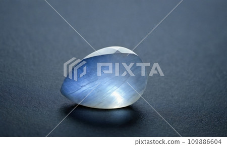 Natural precious moonstone on a gray background. Natural stone adularia Natural precious moonstone on a gray background. Natural stone adularia 109886604