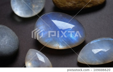 Natural precious moonstone on a brown background. Natural stone adularia Natural precious moonstone on a brown background. Natural stone adularia 109886620