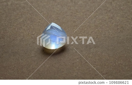 Natural precious moonstone on a brown background. Natural stone adularia Natural precious moonstone on a brown background. Natural stone adularia 109886621