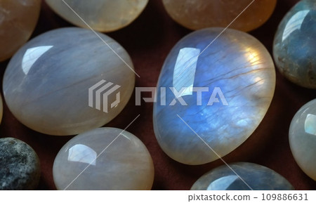 Natural precious moonstone on a brown background. Natural stone adularia 109886631