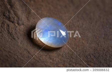 Natural precious moonstone on a brown background. Natural stone adularia Natural precious moonstone on a brown background. Natural stone adularia 109886632
