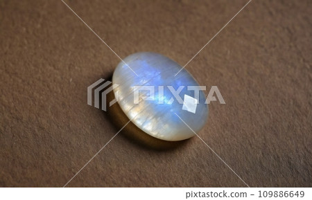 Natural precious moonstone on a brown background. Natural stone adularia 109886649