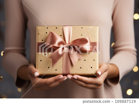 person's hands holding an invitation card with pink ribbon person's hands holding an invitation card with pink ribbon 109887119