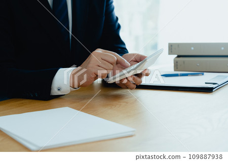 穿著西裝的男人的手用計算機計算 109887938