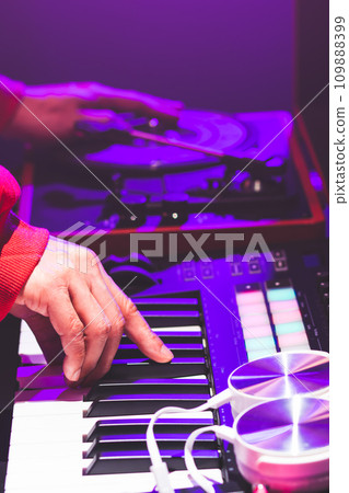 close up male DJ hands remixing dance music on dj set equipment in party 109888399