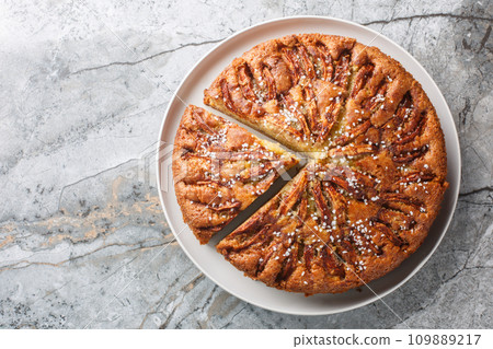 Norwegian apple cake eplekake is plenty of apple slices on sponge batter close-up on a plate. Horizontal top view Norwegian apple cake eplekake is plenty of apple slices on sponge batter close-up on a plate. Horizontal top view 109889217