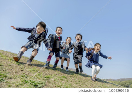 First graders jumping in a park where cherry blossoms bloom 109890626