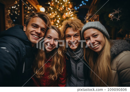 four people are standing over a christmas tree four people are standing over a christmas tree 109890806